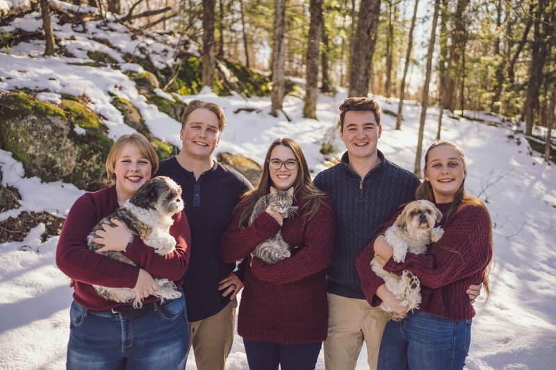 Siblings wearing red and blue with dogs and cats
